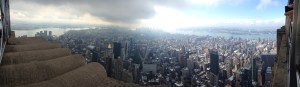 Dramatic panorama from Empire State Building on the same cloudy day with the sky opening up.